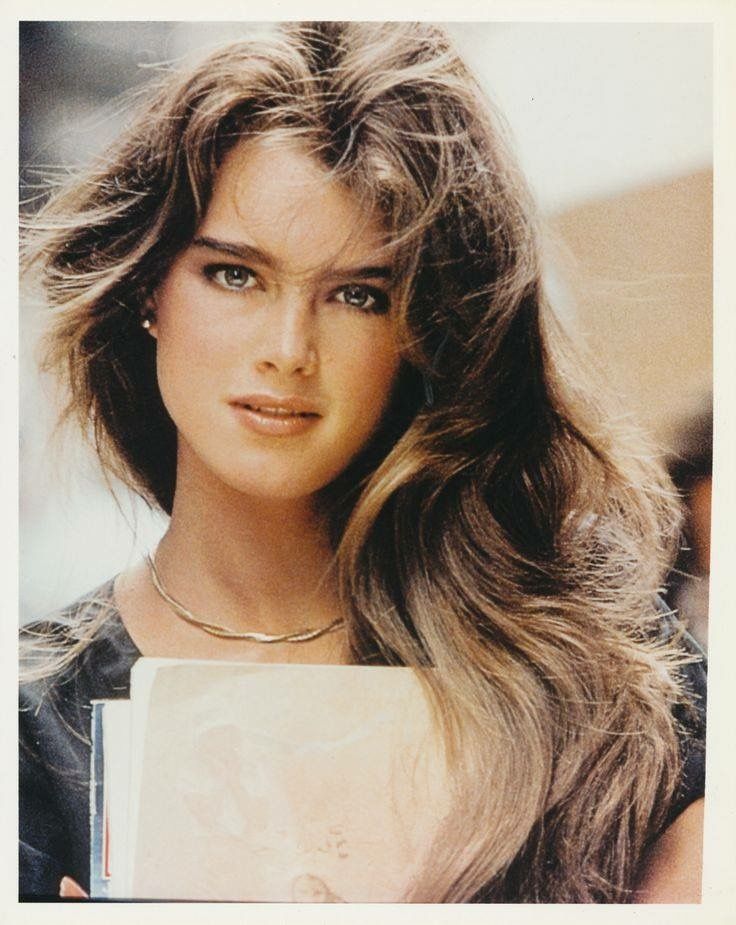 a woman with long hair holding a book