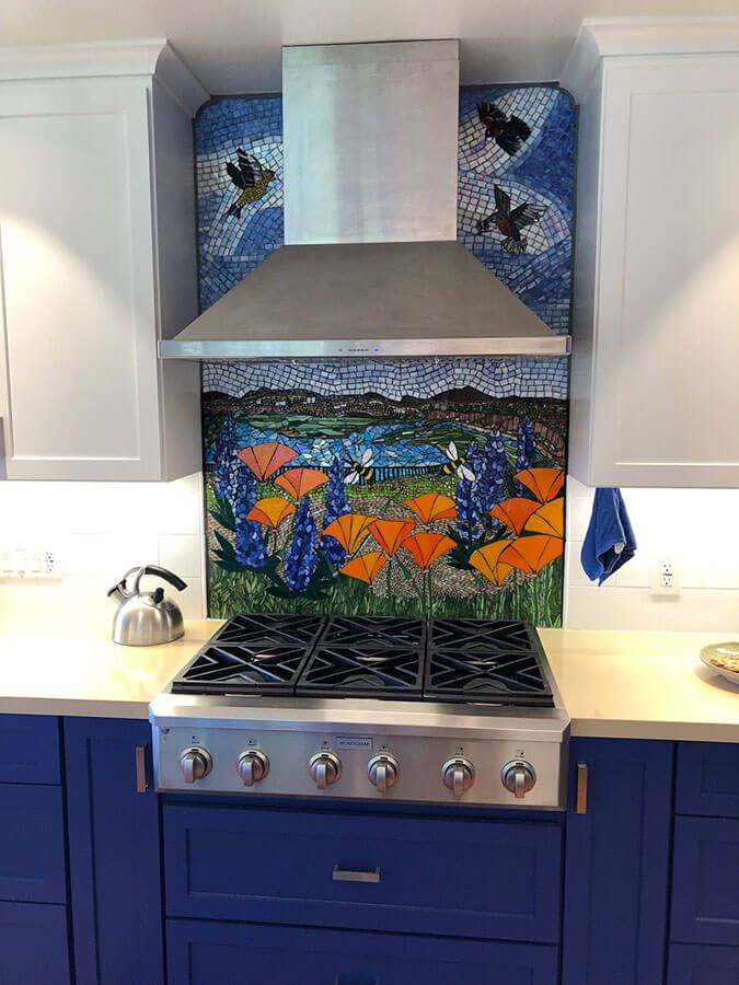 a stove top oven sitting inside of a kitchen next to blue cabinets and counter tops