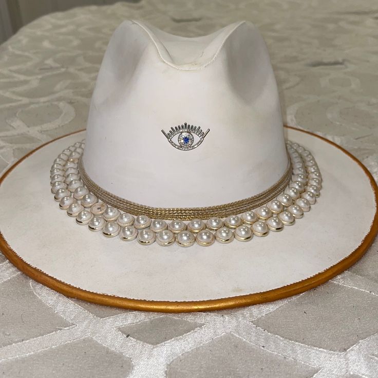 Gorgeous Custom Made Evil Eye Hat . Please See Photos For Reference/ Missing Two Little Pearls And Needs To Be Cleaned/ This Hat Was Imported From Mexico/ Mexicana White Luxury Flat Brim Fedora, Luxury White Flat Brim Fedora, Luxury White Fedora, White Luxury Fedora, Luxury White Fedora Hat, Luxury White Fedora For Kentucky Derby, Luxury White Wide Brim Fedora, White Fedora Felt Party Hat, White Fedora Felt Hat For Party