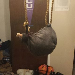 an elephant's head hanging from a rope in front of a door with shoes on the floor