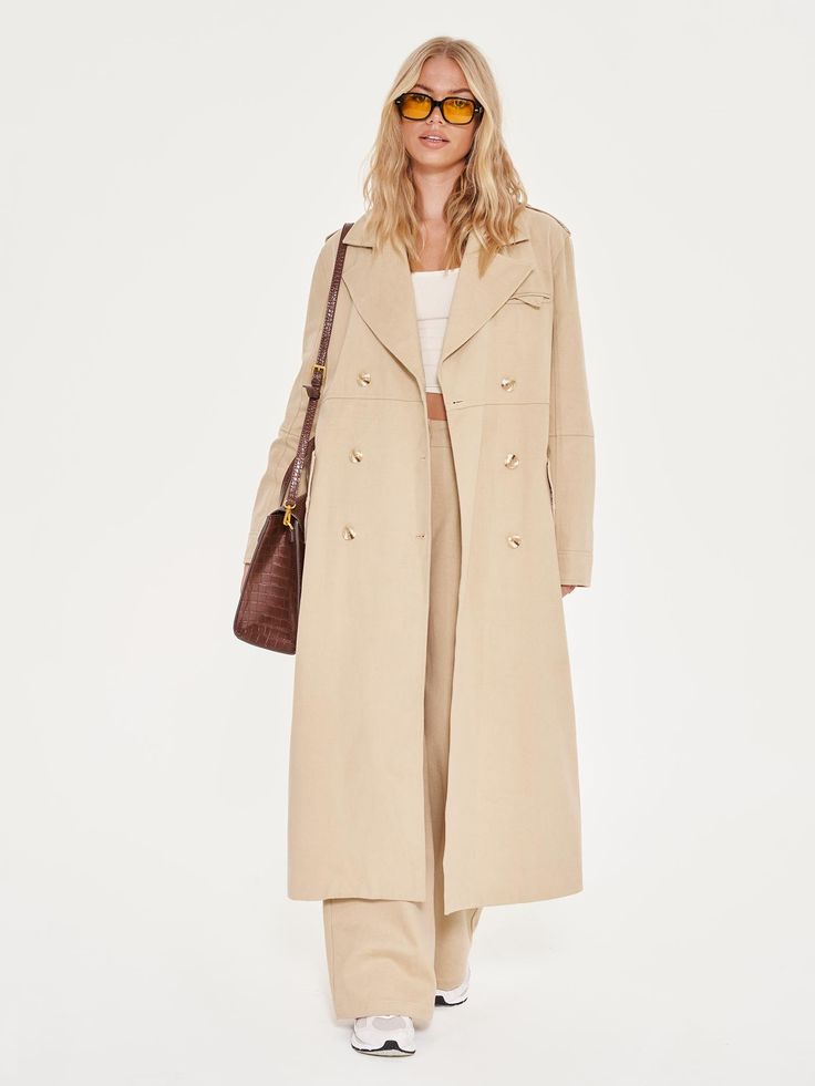 Everyone should have this Extro&Vert Women‘s Belted Trench Coat in their wardrobe. Versatile, structured, classic and ready for all sorts of weather conditions. Cut mid-length, this belted trench coat has the ability to make every outfit feel elevated and polished. Crafted with double-breasted button fastening, military shoulder epaulettes and belted waist. Model: Height 5’9“ / Bust 32½B / Waist 25” / Hips 37“ / UK Size 8. Designed in the UK. Dry clean only. Small: UK 6 - 8 / US 2 - 4Medium: UK Chic Spring Pea Coat With Belted Cuffs, Classic Pea Coat With Belted Cuffs For Spring, Long Gabardine Pea Coat For Spring, Spring Gabardine Long Pea Coat, Office Long Coat With Belted Cuffs, Spring Long Gabardine Pea Coat, Chic Belted Pea Coat With Notch Lapel, Timeless Belted Long Sleeve Outerwear, Timeless Long Sleeve Outerwear With Belted Cuffs