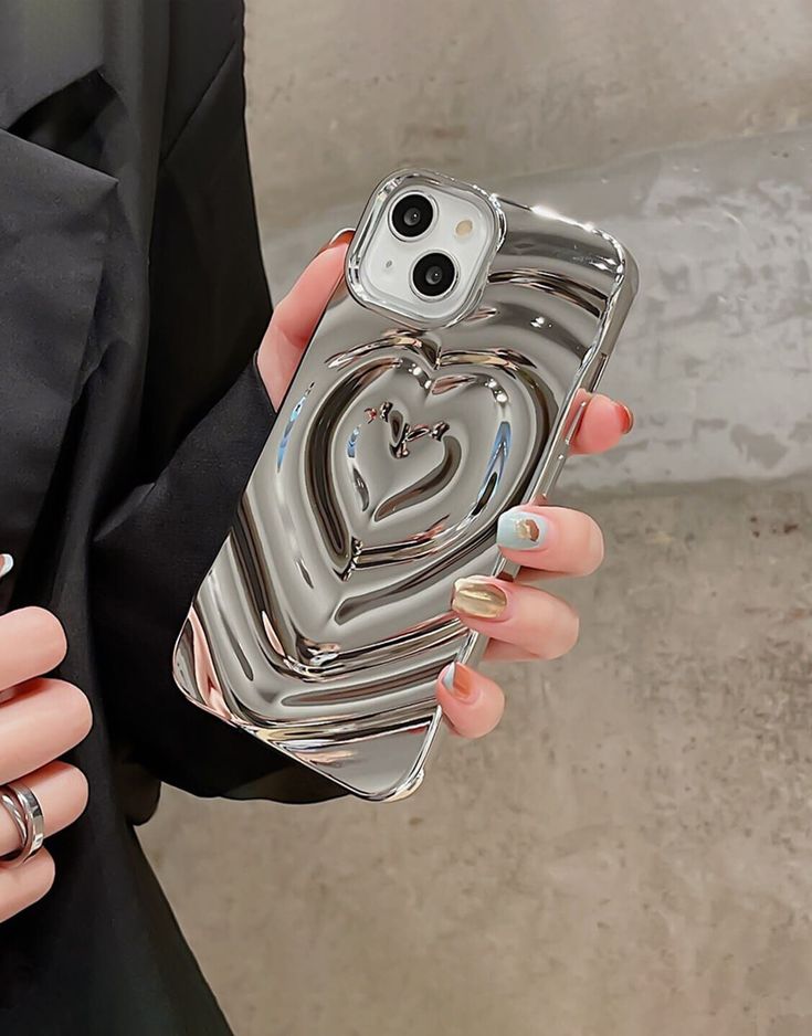 a woman holding a phone case with a heart on it