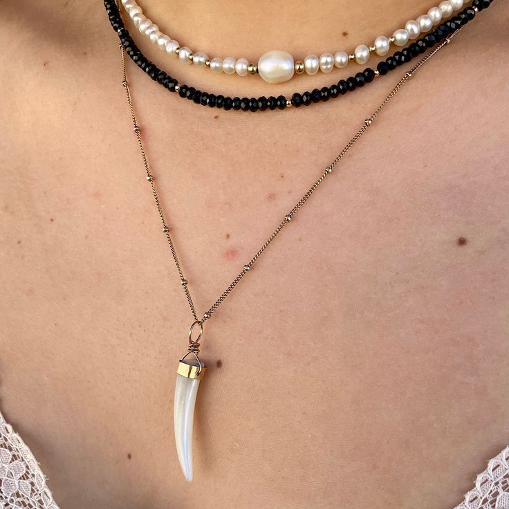 As uniquely brilliant as the woman who wears it, our Luminous Mother of Pearl Tusk Necklace is a stunning addition to your jewelry collection and we're sure it's about to become your next obsession. Each one is an individual treasure hand-carved from mother of pearl and accented with a hand-made bezel setting. Gorgeous and unique this custom-made piece is perfect for layering. Each tusk measures approximately 1 1/4 to 1 1/2 in and is hung on our popular satellite chain. Available in 14kt gold fi Gold Long Single Strand Necklace, Gold Double Strand Jewelry With Lobster Clasp, Elegant Gold Crystal Necklace As Gift For Her, Elegant Gold Crystal Necklace For Her, Spiritual Jeweled Necklaces, Gold Double Strand Necklace With Lobster Clasp, Spiritual Gold Long Necklace, 14k Gold Choker Jewelry Gift, Brass Rose Gold Necklace For Jewelry Making