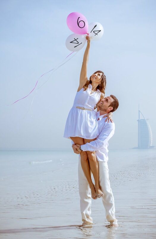 a man and woman are holding balloons in the air