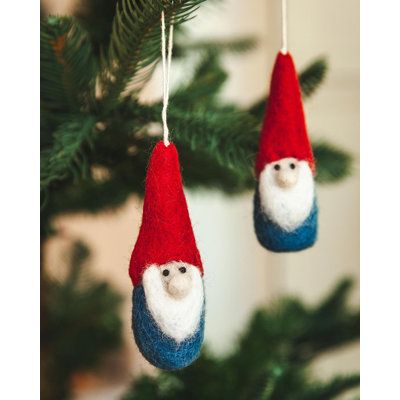 two gnome ornaments hanging from a christmas tree