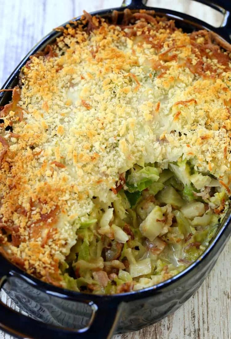 a casserole dish with cheese and vegetables in it on a wooden table top