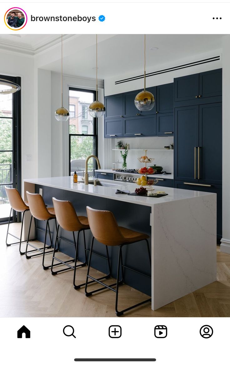 an image of a kitchen with blue cabinets and bar stools on the counter top