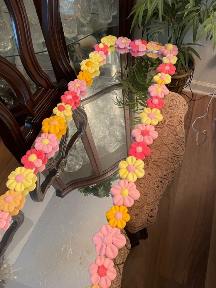 a mirror that has flowers on it in the shape of a heart and is next to a potted plant