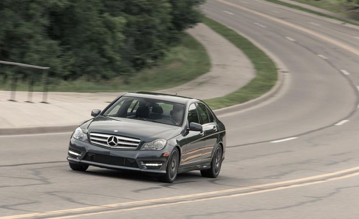 a mercedes c - class driving on a curved road