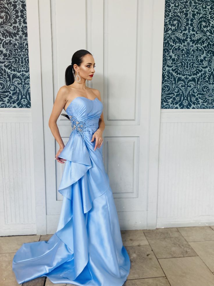 Designer's Notes: You will fall in love at the first sight with this elegant yet simple strapless baby blue maxi evening dress. Designed with a sweetheart neckline, an exaggerated brooch applique at front, curve-hugging silhouette, pure color, a full-length dress cut with a dramatic train, this stunning boutique gown for women is suited for your next formal event beyond summer. Product Details: Style: Strapless Blue Gown; Sweetheart Neckline Bling and Beaded Brooch Applique in Front at Side Two Maxi Evening Dress, Gown For Women, Hugging Silhouette, Blue Gown, Full Length Dress, Blue Maxi, Maxi Dress Evening, Beaded Brooch, Dress Cuts