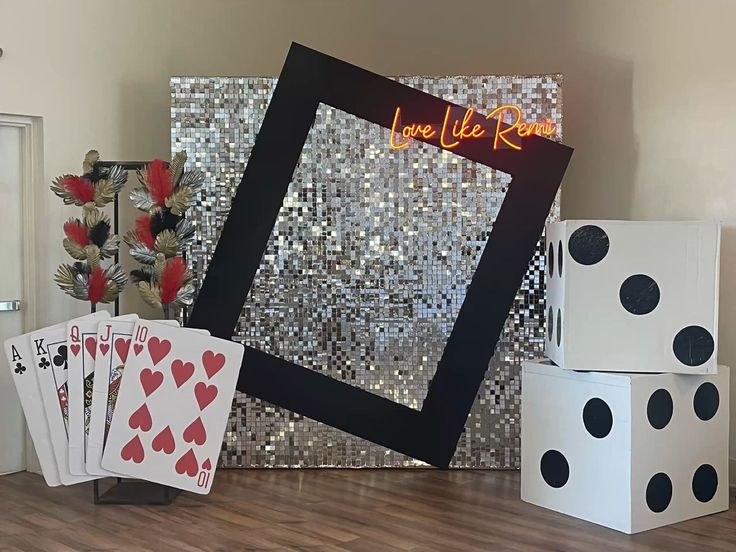 some cards and dices are on the floor in front of a wall with a sign that says love like rain