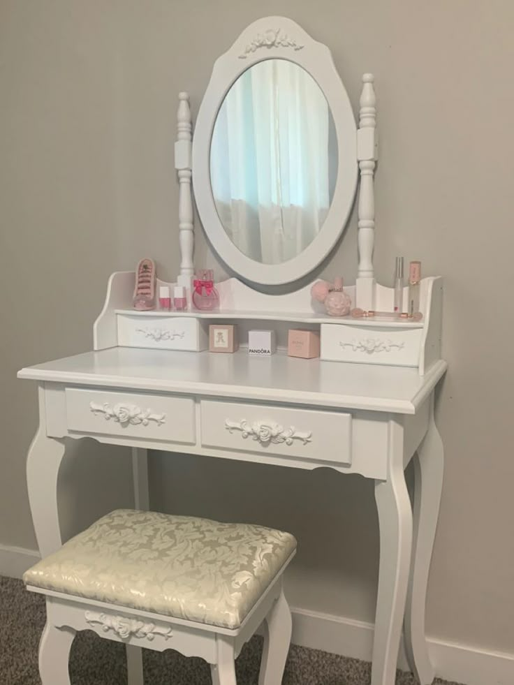 a white dressing table with a mirror and stool