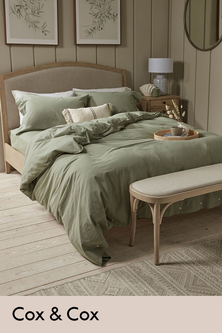 a large bed sitting in a bedroom next to a table with a tray on it