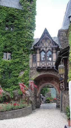 an old building with ivy growing on it's sides and a stone walkway leading to the entrance