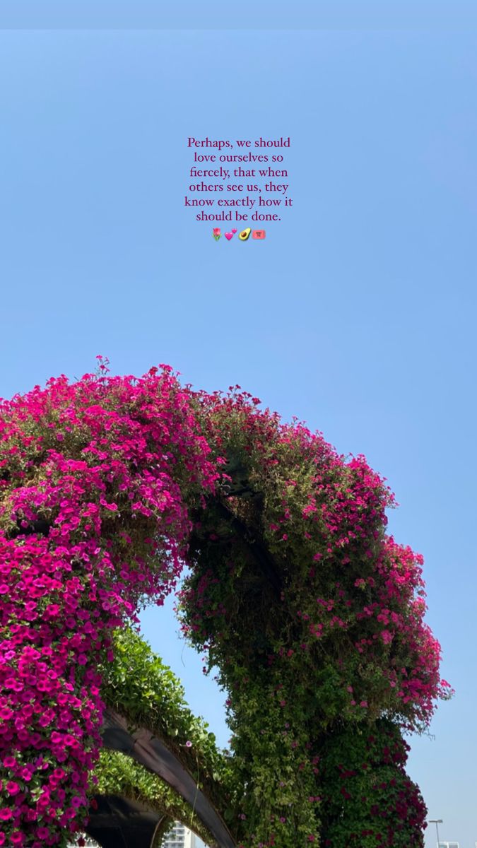 an arch covered in purple flowers with a quote above it