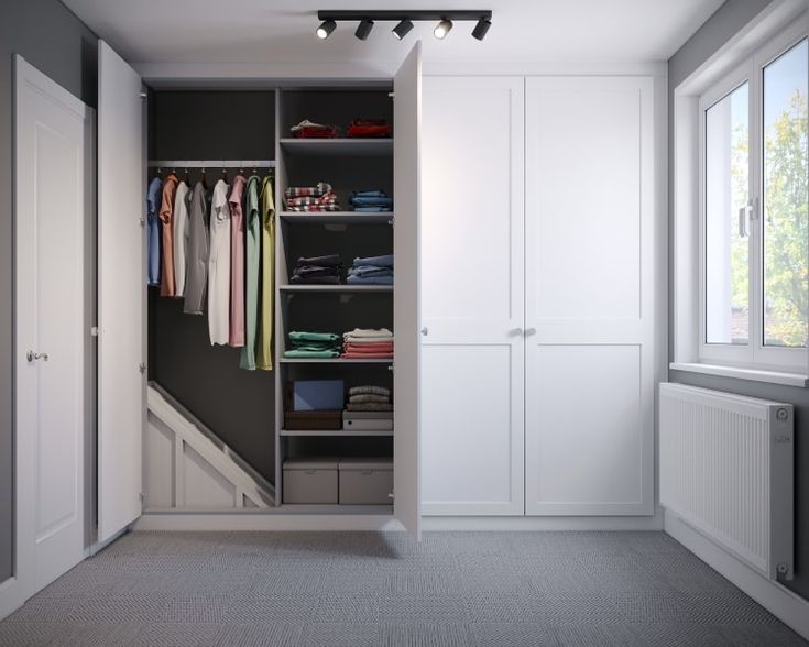 an empty closet with clothes hanging on the walls and drawers in front of it, next to a radiator