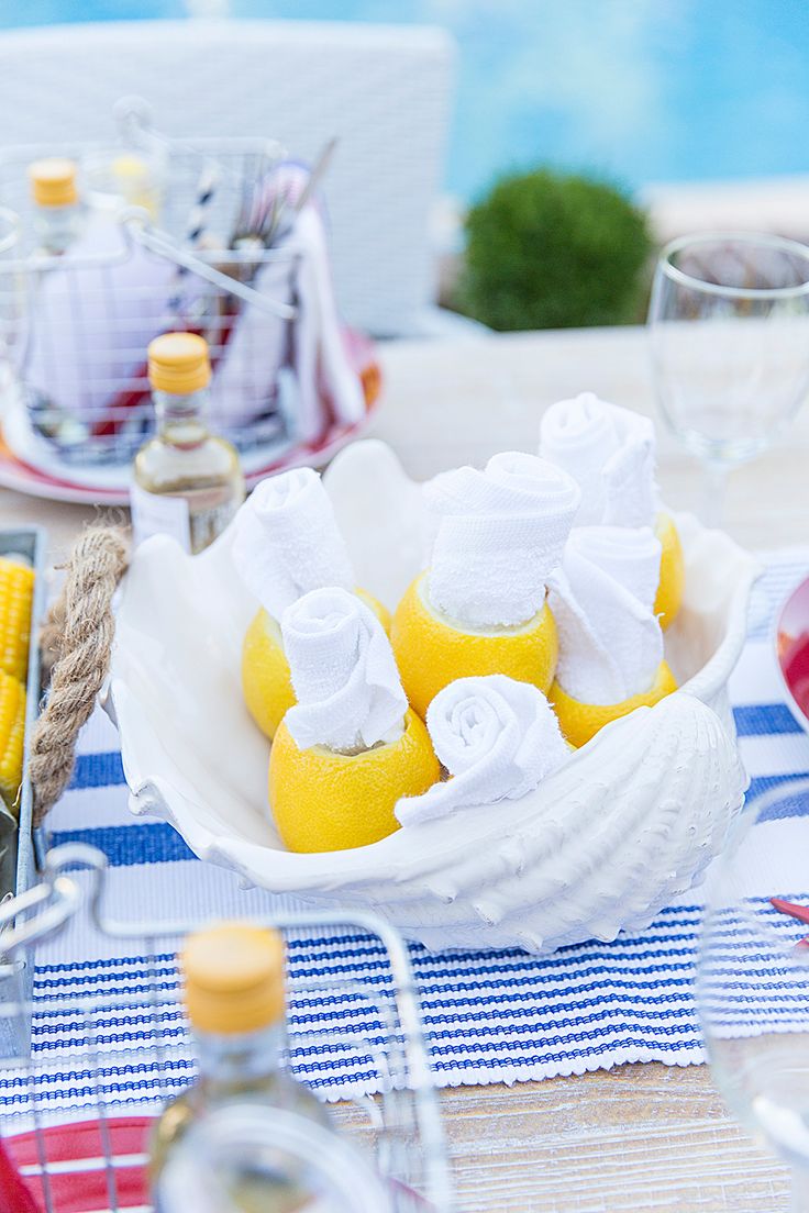 a bowl filled with lemons on top of a blue and white striped table cloth