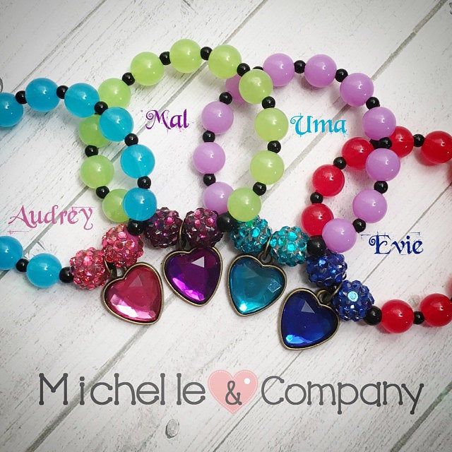 several bracelets with heart charms and name tags on the front, one is multicolored