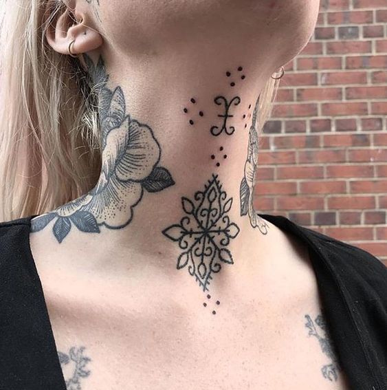 a woman with tattoos on her neck and chest