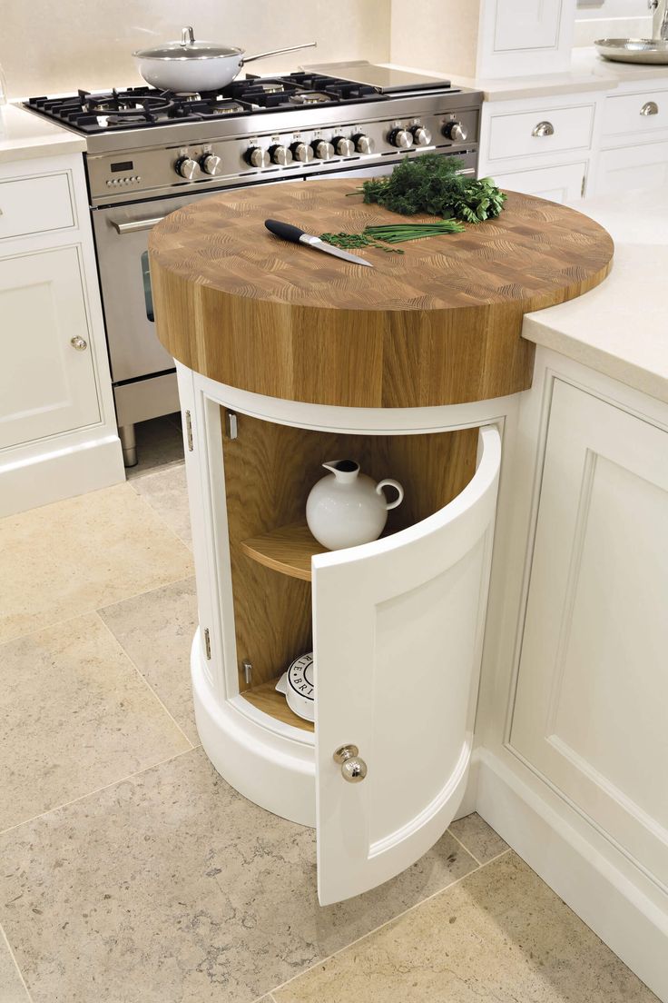 a kitchen island with a cutting board on it in front of an oven and sink