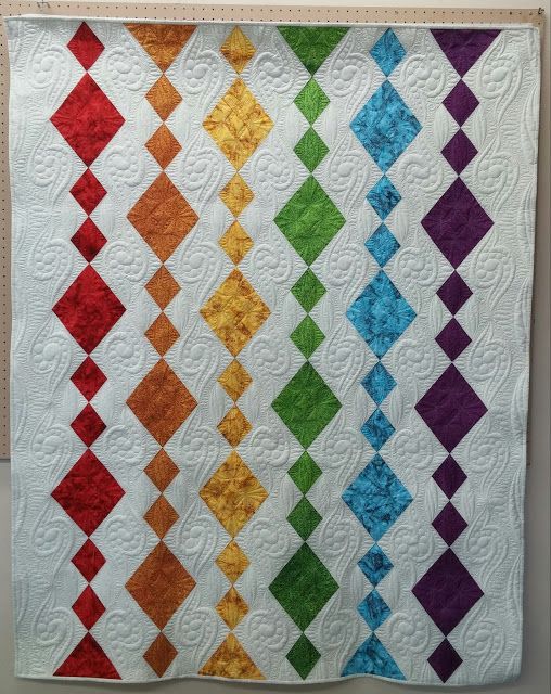 a colorful quilt hanging on the wall