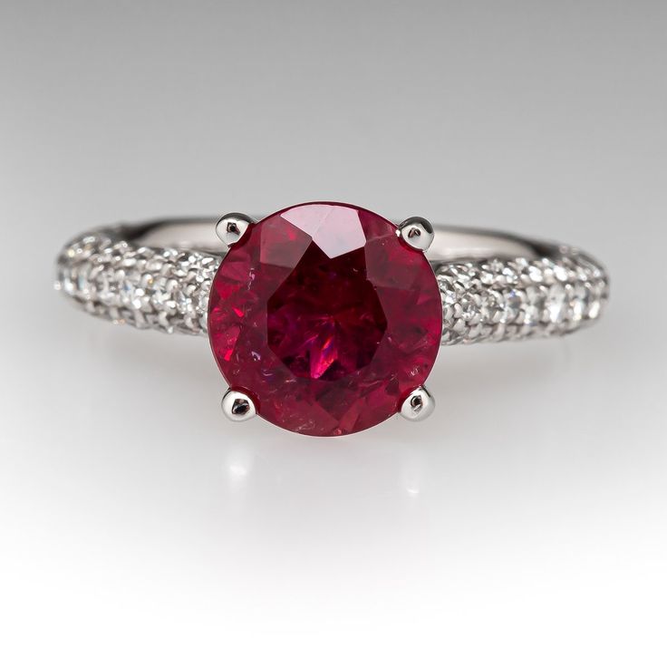 This pretty ring is centered with one (1) round modified brilliant cut natural tourmaline set into a four-prong head. The shank is accented with forty-six (46), bead set, round brilliant cut diamonds on each side. The side face of the ring are each accented with three (3), bead set, round brilliant cut diamonds. The ring measures 8.0mm at the top, rises 9.6mm above the finger, tapering to 2.3mm wide and 1.6mm thick at the base of the shank. Signed Gabriel & Co 14K S128023. It is currently a size Luxury Ruby Ring With Gemstone Accents, Ruby Diamond Ring With Accent Stones And Round Cut, Diamond Ring With Center Stone And Lab-created Ruby, Exquisite Ruby Ring With Center Stone, Dazzling Ruby Ring With Brilliant Round Cut, Dazzling Brilliant Cut Ruby Ring, Dazzling Brilliant Cut Round Ruby Ring, Round Diamond Ring With Center Lab-created Ruby, Classic Ruby Ring With Gemstone Accents For Promise