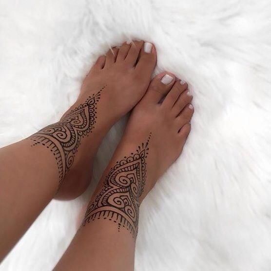 a woman's legs with hendix tattoos on them and white furnishing