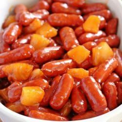 a white bowl filled with lots of hot dogs