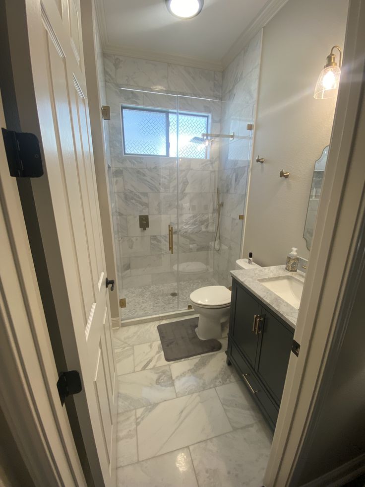 a bathroom with a toilet, sink and shower