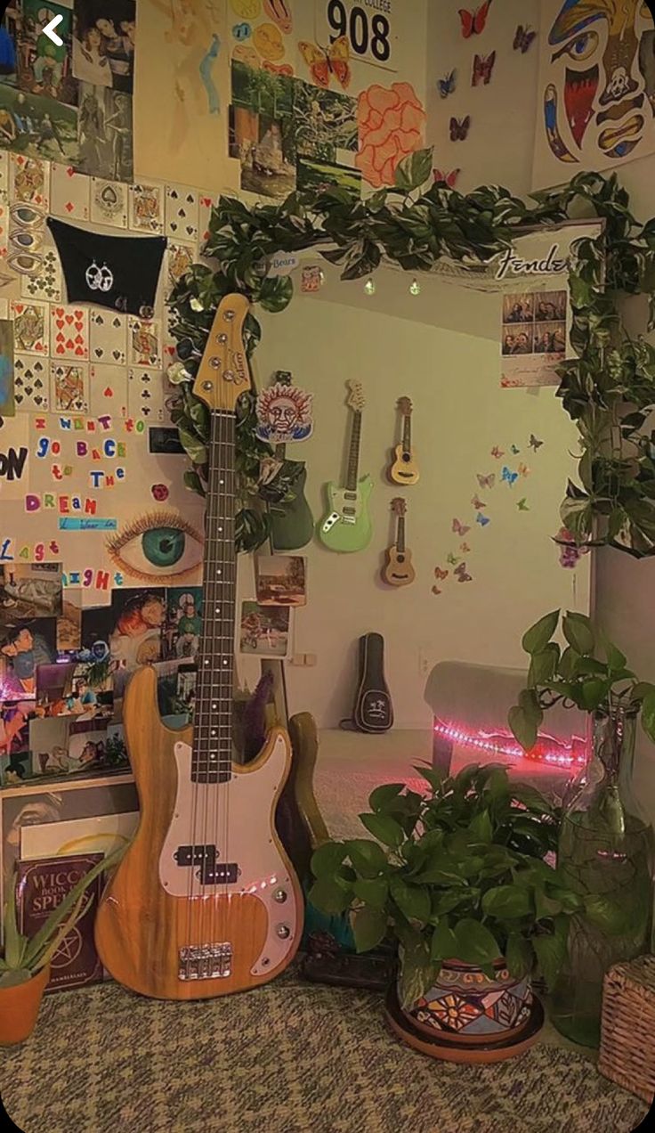 a guitar sitting on top of a table next to a potted plant in front of a mirror