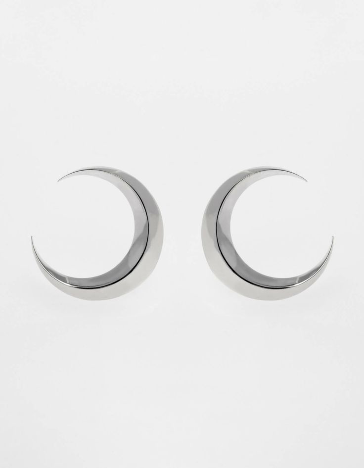 Symmetrical moon-shaped earrings made of sterling silver or sterling silver plated with 24 ct gold. Motif diameter: 24 mm. Decorative engraving on the reverse.We observe the phases of the Moon on Earth trying to solve the mystery of lunar attraction, but one side of this peculiar celestial body is always hidden in the shade of the Sun. Gold Motif, The Phases Of The Moon, Phases Of The Moon, Moon Phases, On Earth, The Moon, Silver Earrings, Silver Plated, Gold Plate