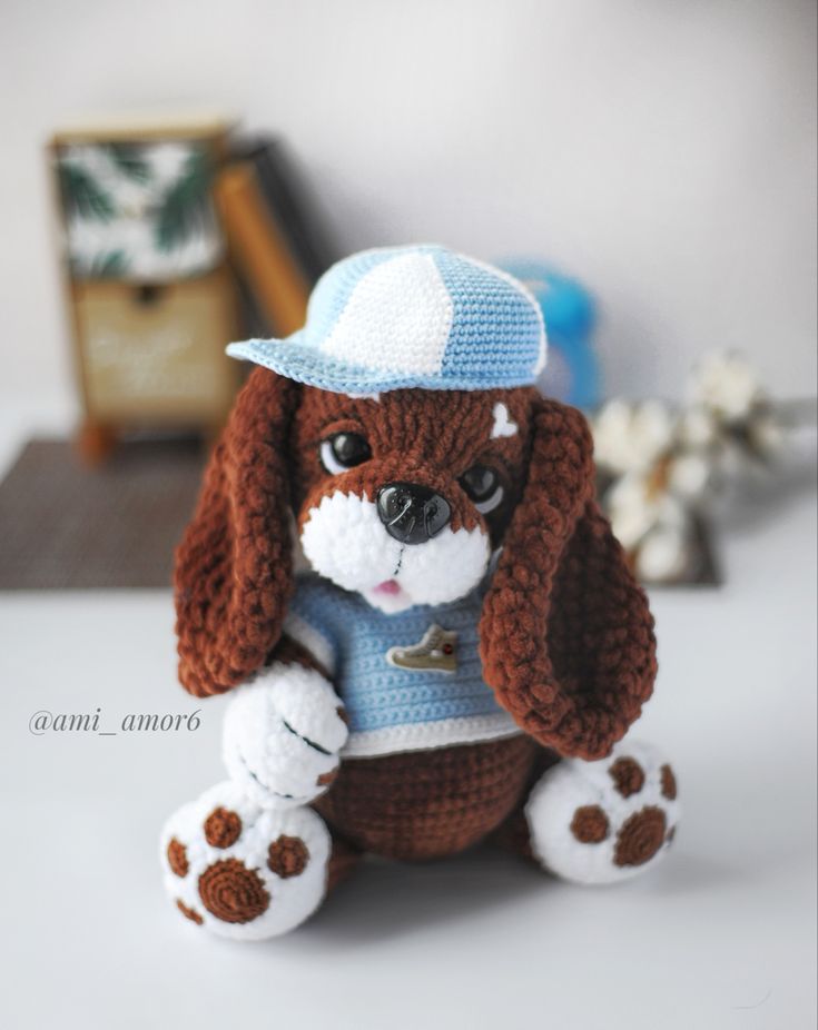 a brown and white dog sitting on top of a table next to a stuffed animal