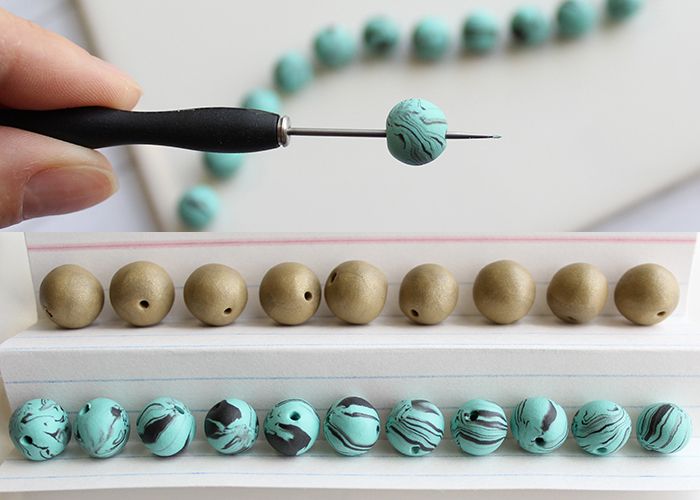 a person is using a needle to cut beads