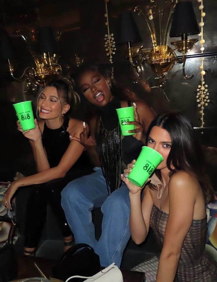 three women holding green cups in their hands