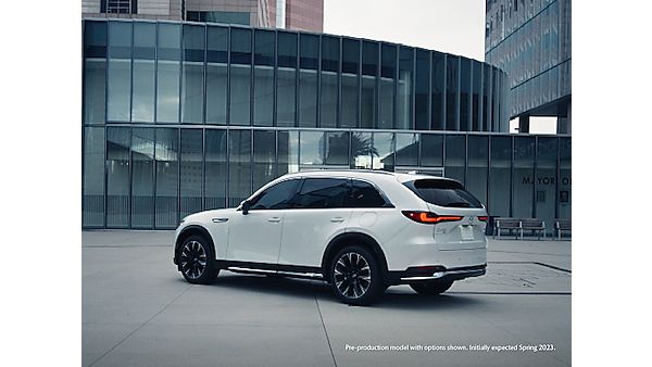 a white suv parked in front of a large building with glass walls and windows on the side