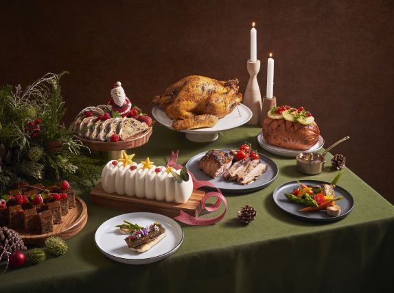 a table topped with lots of different types of cakes and desserts next to candles