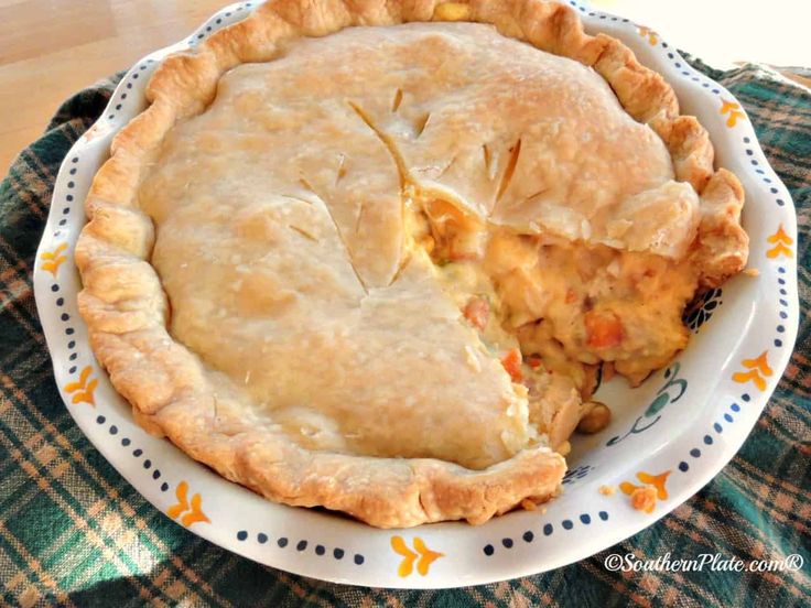 a pie and some food on a plate with a green checkered table cloth in the background