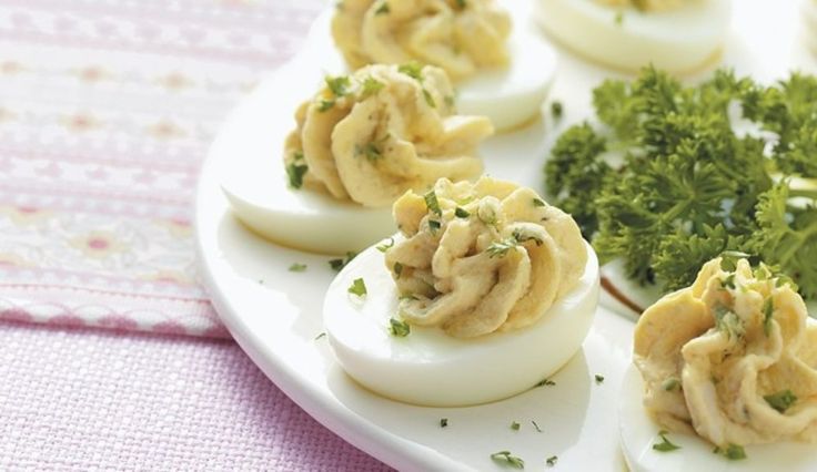 several deviled eggs are on a plate with parsley