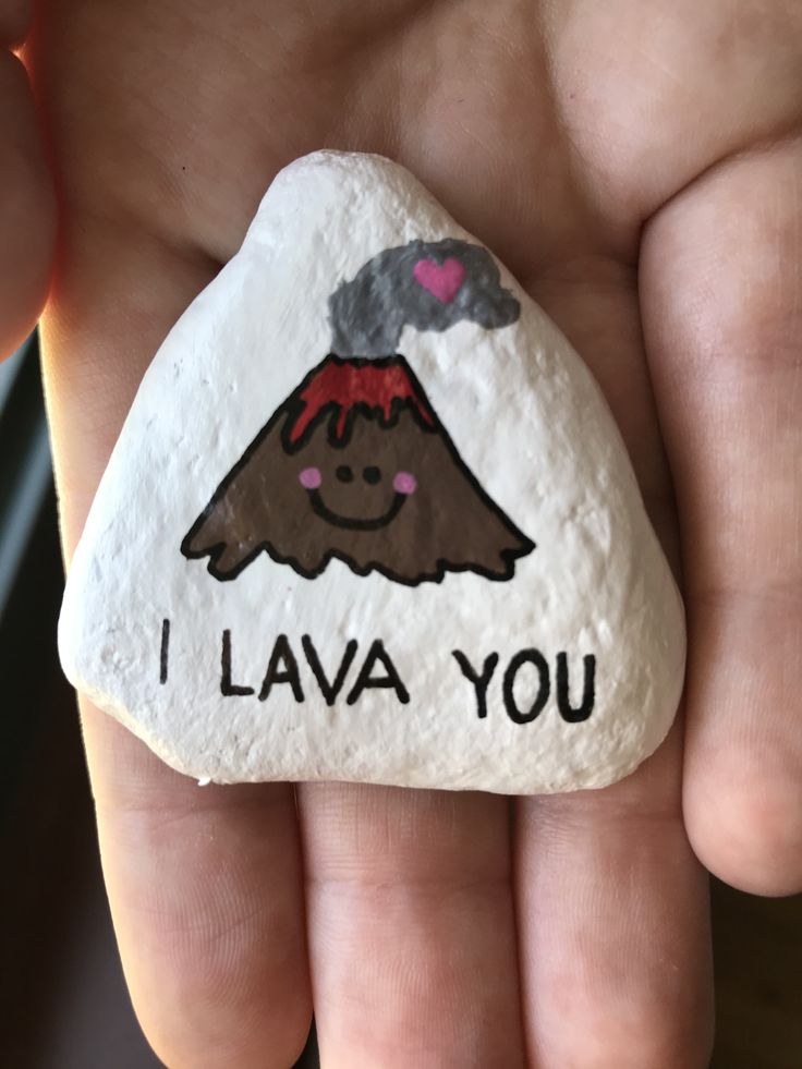 a hand holding a rock with a volcano painted on it that says i lava you