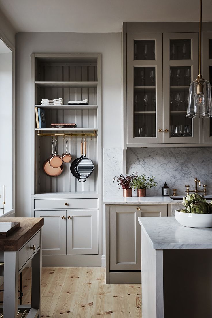 a kitchen with white cabinets and wooden floors