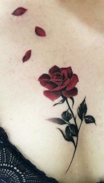 a woman's chest with a rose tattoo on it