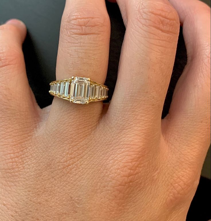 a woman's hand with a ring on it that has three baguettes