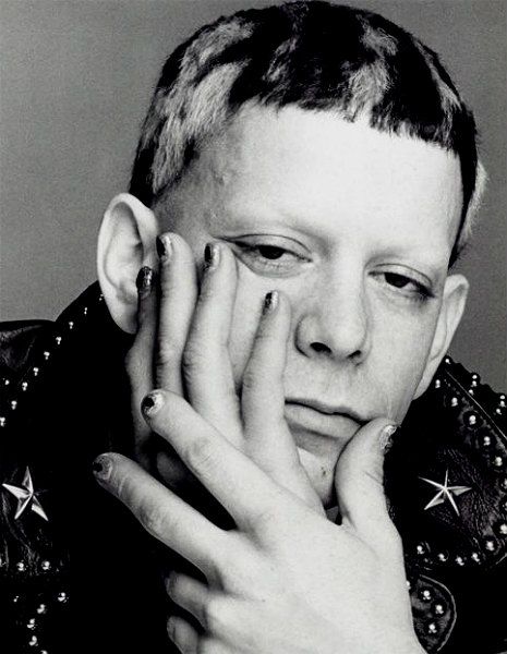 a black and white photo of a young man with stars on his fingernails