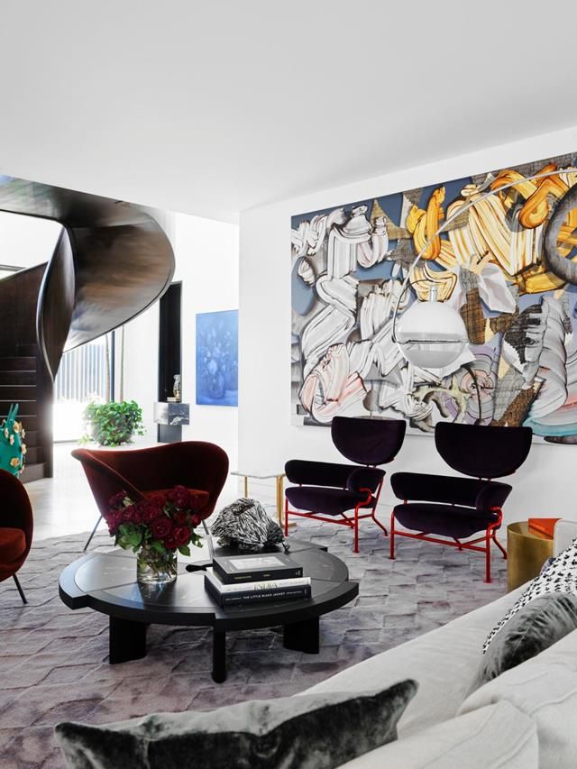 a living room filled with furniture and a painting on the wall