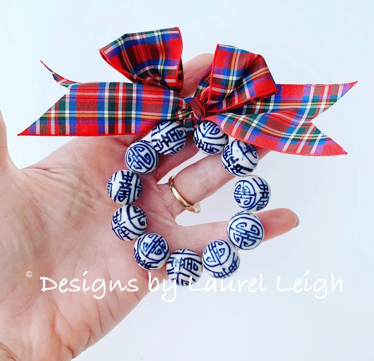 a woman's hand holding a red, white and blue ribbon with designs on it