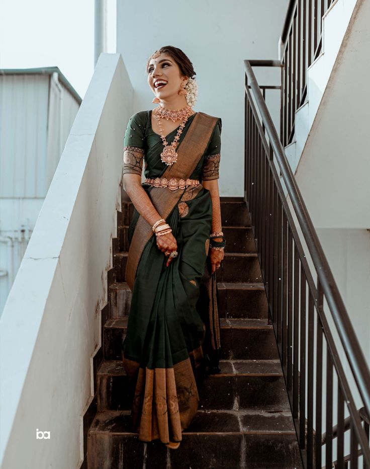 a woman in a green sari standing on some stairs