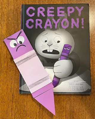 the book creepy crayon is next to an origami cat with a purple pen