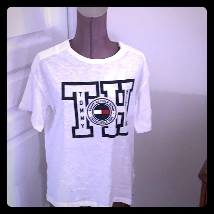 Women Tommy Hilfiger Tee Shirt. A Part Of Shoulder Closure With Magnet. Trendy Tan Short Sleeve Shirt, Trendy Tommy Hilfiger Cotton T-shirt, Tommy Hilfiger Graphic Print Short Sleeve Shirt, Tommy Hilfiger Spring Short Sleeve Shirt, Tommy Hilfiger Short Sleeve Shirt For Spring, Summer Graphic Tee Shirt In Tan, Tan Graphic Tee Shirt For Summer, Tan Graphic Tee For Summer, Trendy Tan Cotton Top