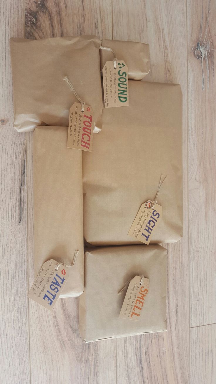 three packages of brown paper with tags on them sitting on a wooden floor next to each other