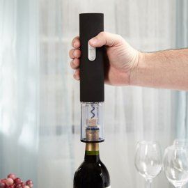 a person holding a wine bottle in front of a corkscrew with some wine glasses on the table